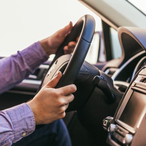 Close-up of a male hand in a modern car